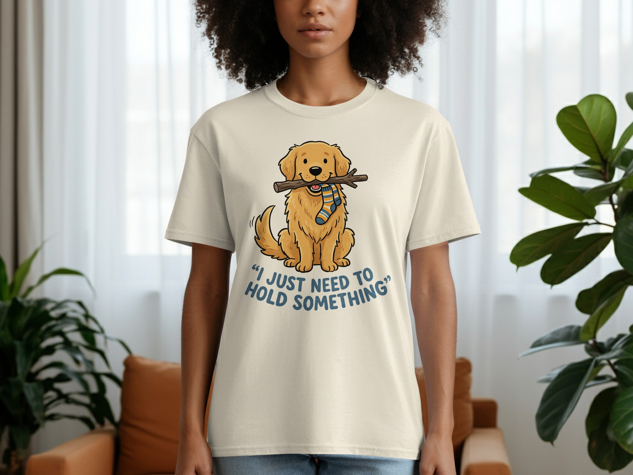 Beige t-shirt with cartoon dog holding stick and text "I just need to hold something".