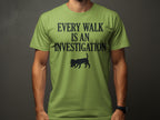 Green t-shirt with "Every Walk Is An Investigation" and a dog silhouette.