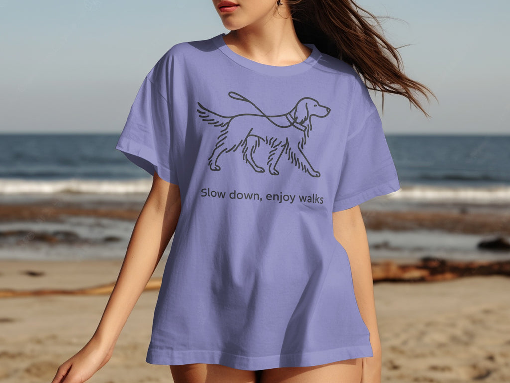 Lilac t-shirt with line drawing of a walking dog and text "Slow down, enjoy walks."