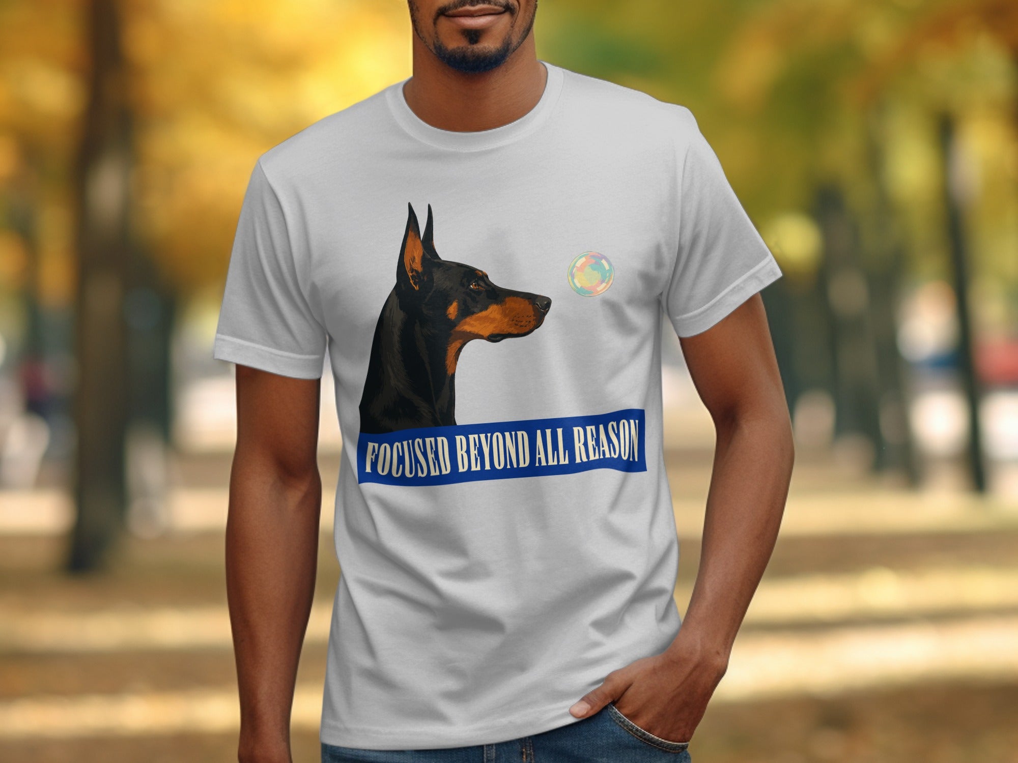 Doberman pinscher wearing t-shirt with "Focused Beyond All Reason" text.