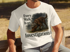 White t-shirt with dark text reading "Every Walk Is an Investigation" and a chocolate lab wearing a detective hat.