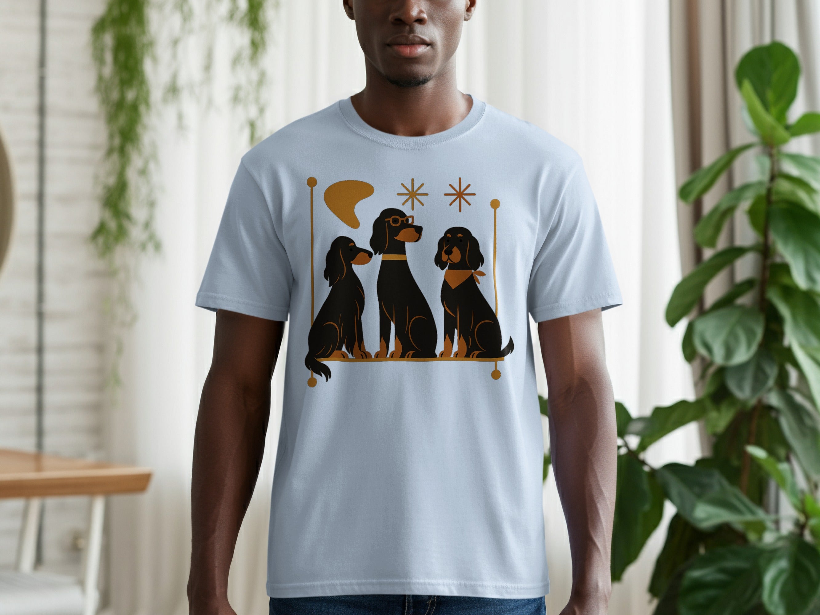 Light blue t-shirt with a graphic of three black dogs with gold accents.