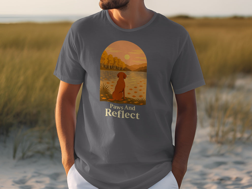 T-shirt with graphic of dog by lake with text "Paws And Reflect".