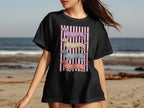 Black t-shirt featuring four stacked, illustrated dachshunds on a pink striped background.
