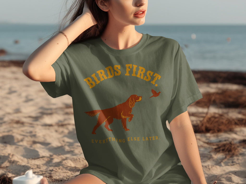 Green t-shirt with text "BIRDS FIRST EVERYTHING ELSE LATER" and dog graphic.