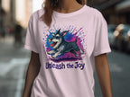 T-shirt features a running schnauzer with colorful paint splatters and text "Unleash the Joy".