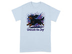 Light blue t-shirt with black and tan dog running, watercolor splashes and text "Unleash the Joy".