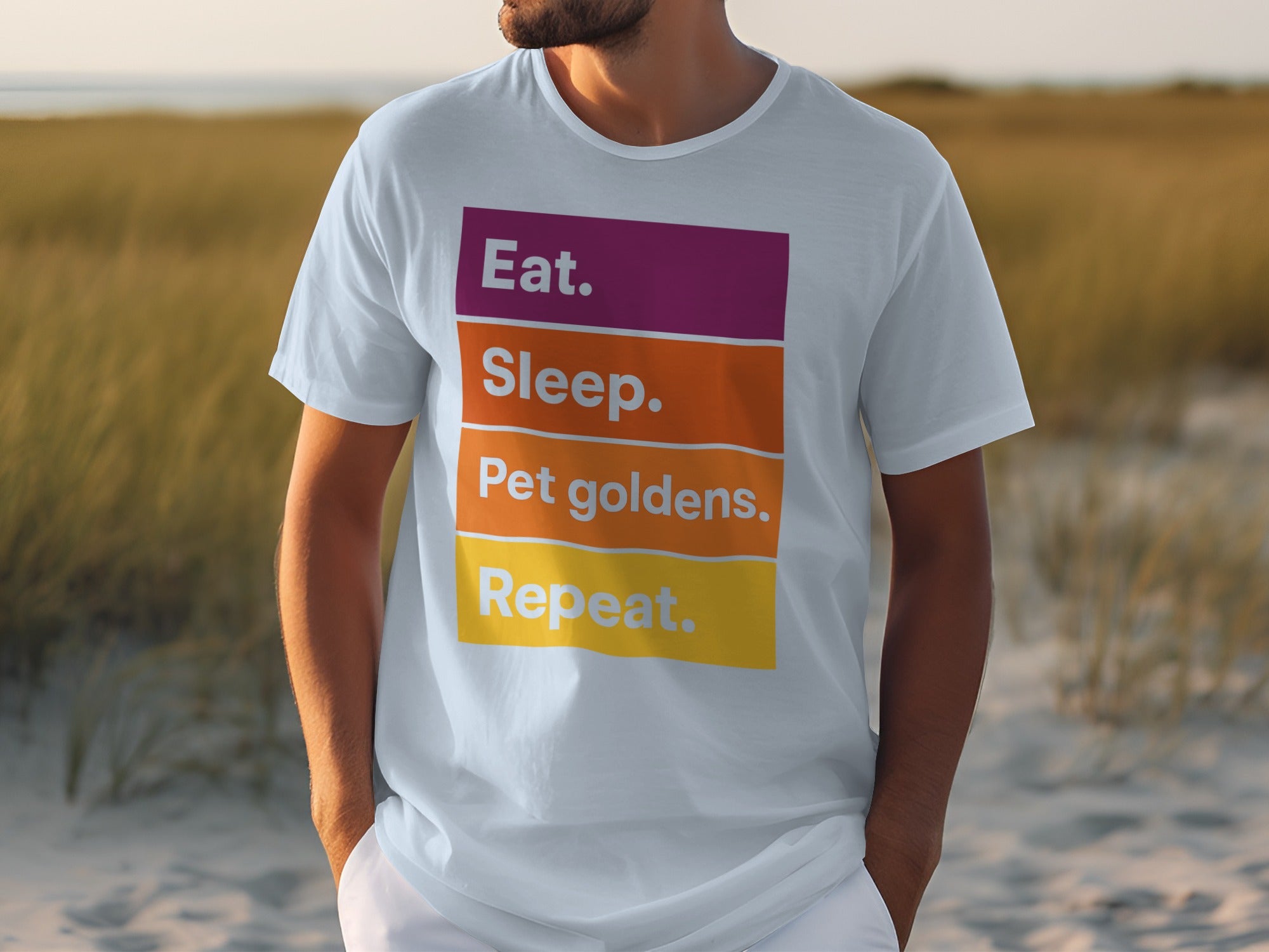 White t-shirt with "Eat. Sleep. Pet goldens. Repeat." text in colorful blocks.
