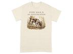 Beige t-shirt with a brown and white dog sniffing the ground in a forest.