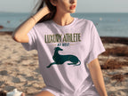 Woman wearing a white t-shirt with "LUXURY ATHLETE AT REST" and a greyhound.