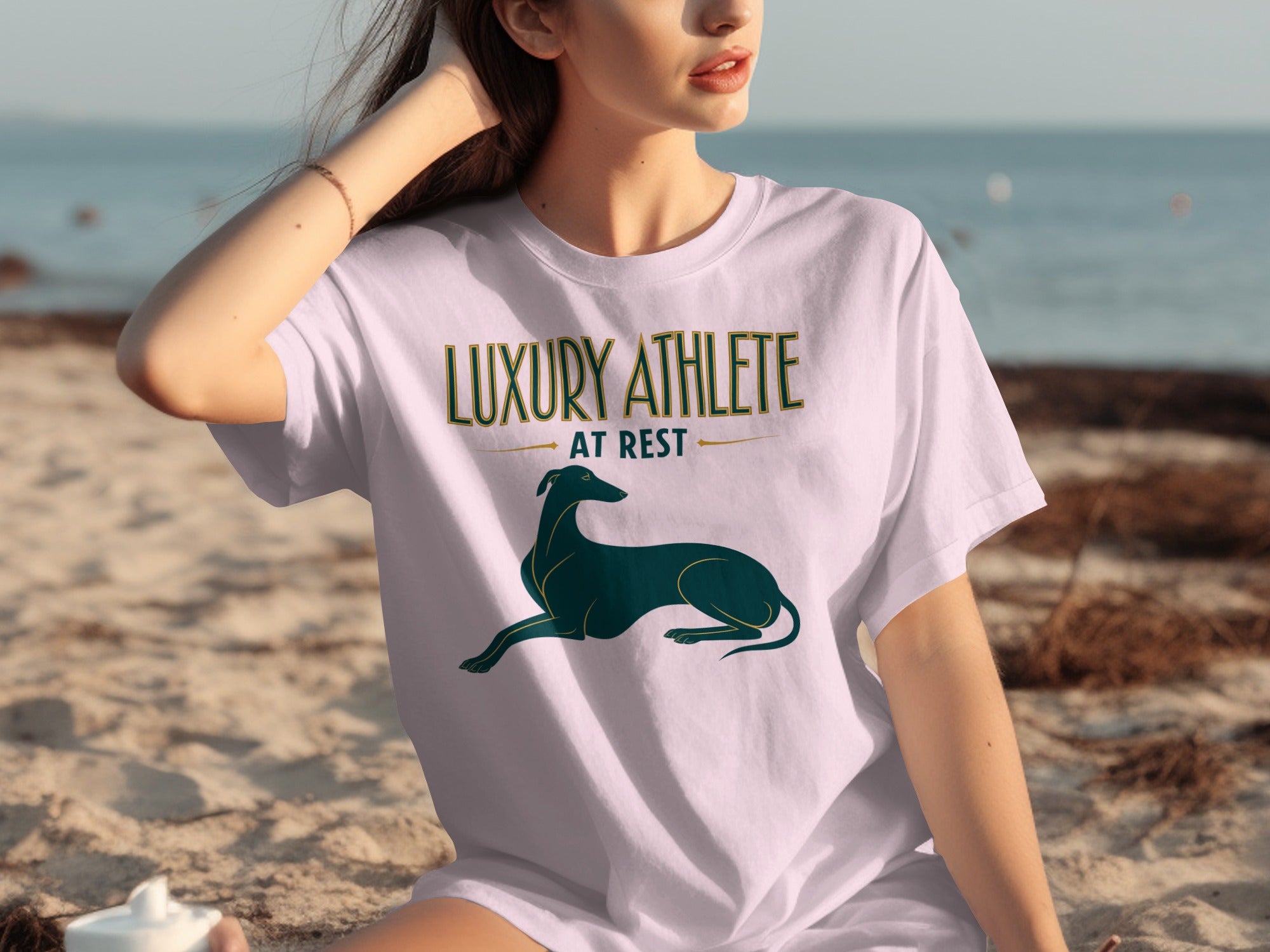 Woman wearing a white t-shirt with "LUXURY ATHLETE AT REST" and a greyhound.
