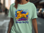 Green t-shirt with a running golden retriever and the text "Unleash the Joy."