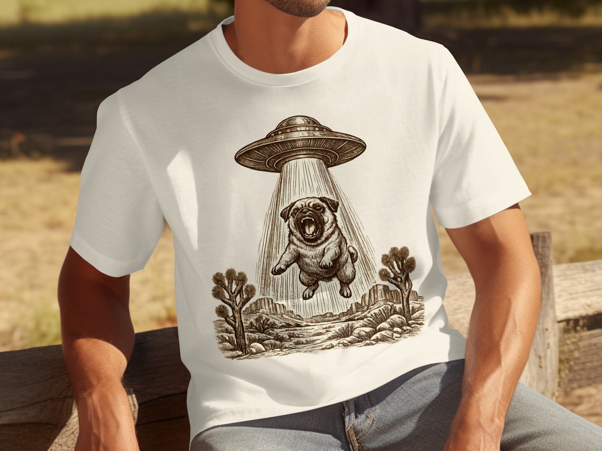 T-shirt graphic: UFO abducting a pug over a desert landscape.