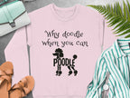 Pink sweatshirt with "Why doodle when you can poodle" text and poodle graphic.