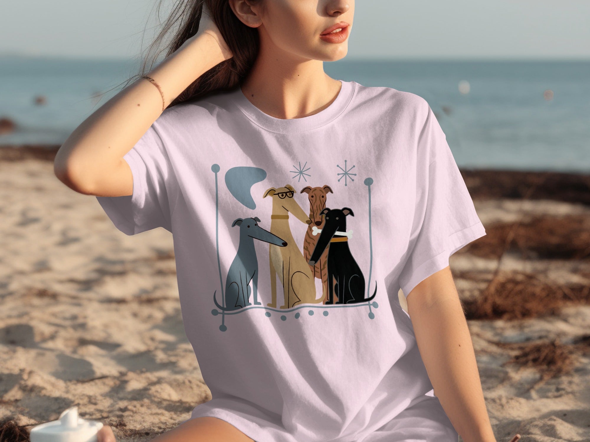 T-shirt with retro graphic of four stylized dogs sitting on beach.