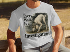 White t-shirt with artwork of a poodle detective saying "Every Walk Is an Investigation."