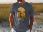 T-shirt with dog looking at sunset over lake, text "Paws And Reflect".