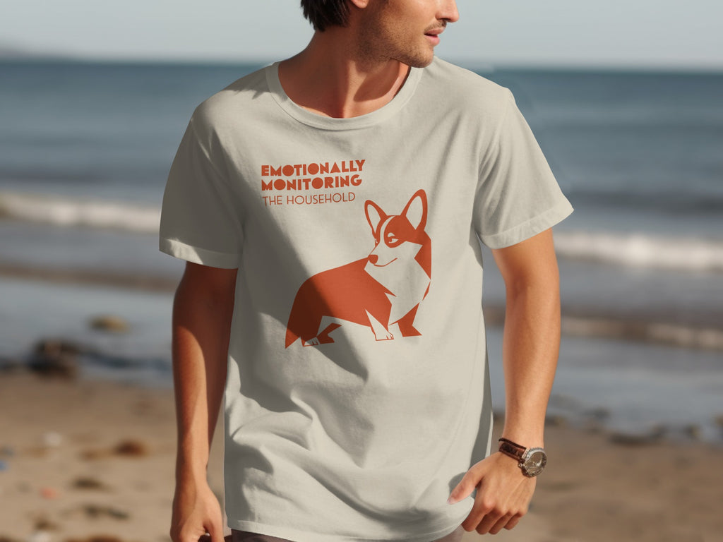 Cream t-shirt with orange corgi graphic and text "EMOTIONALLY MONITORING THE HOUSEHOLD".