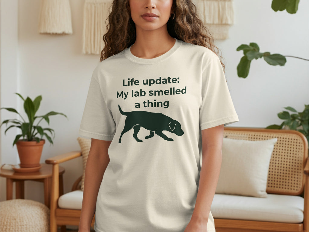 Cream t-shirt with black silhouette of a dog and text "Life update: My lab smelled a thing".