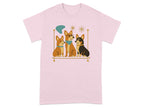 Pink t-shirt with cartoon illustration of three corgi dogs sitting on a shelf.