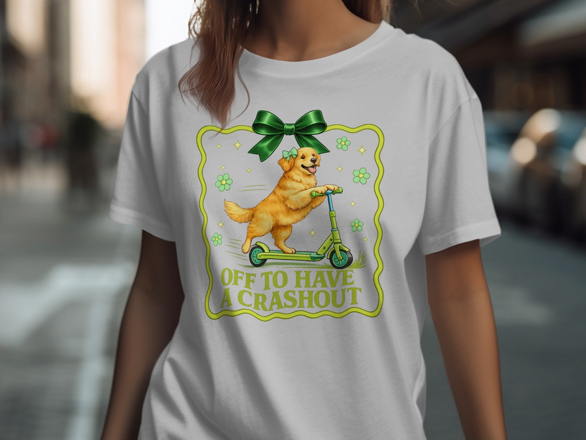 Golden retriever on scooter with text "OFF TO HAVE A CRASH OUT" and green bow.