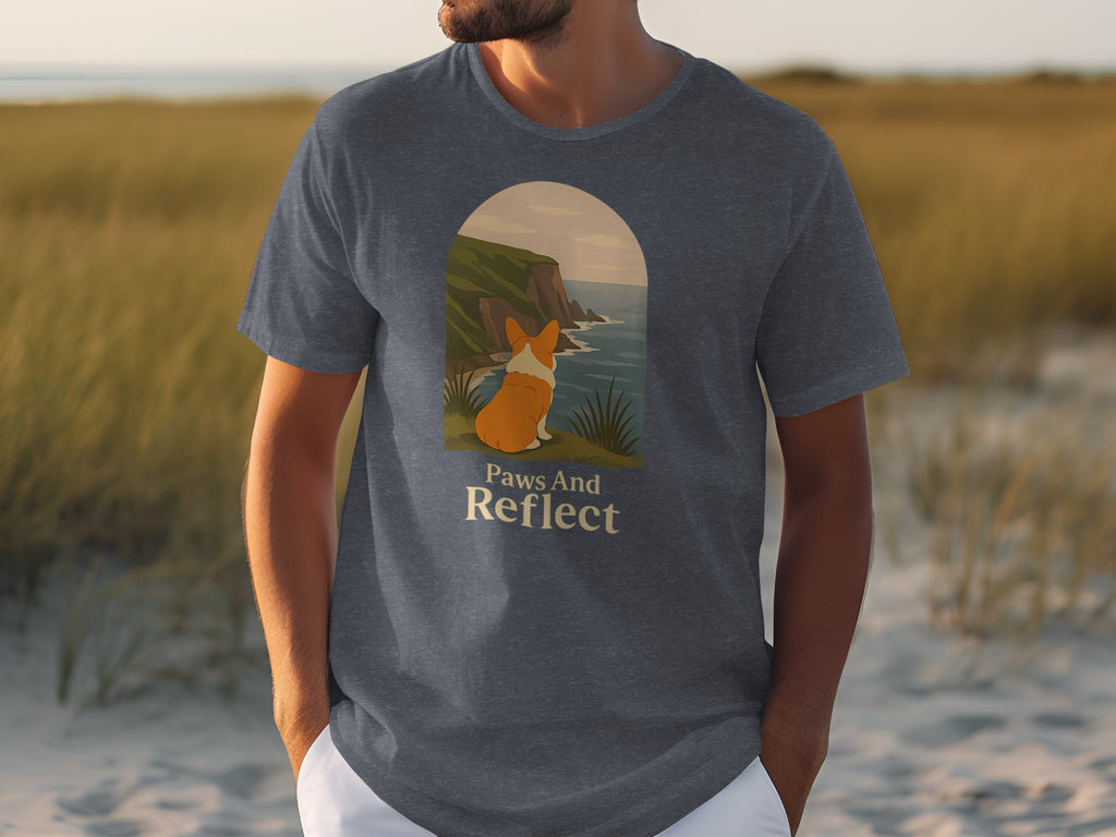 T-shirt with a corgi looking at a cliffside ocean view and text "Paws And Reflect".