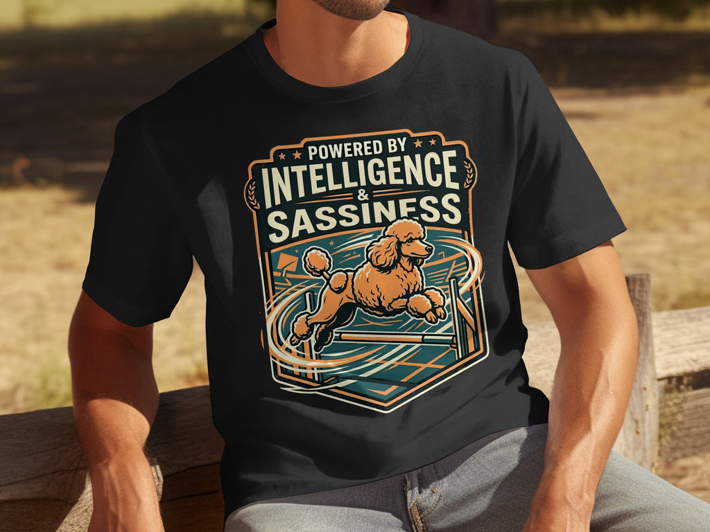 Black t-shirt with orange poodle jumping over obstacle, "Powered By Intelligence & Sassiness" text.