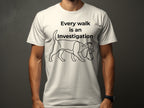 White t-shirt with a dog wearing a detective hat and the text "Every walk is an investigation".