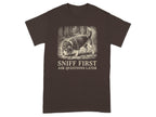 Brown t-shirt with beagle dog wearing hat, sniffing cobblestone path.