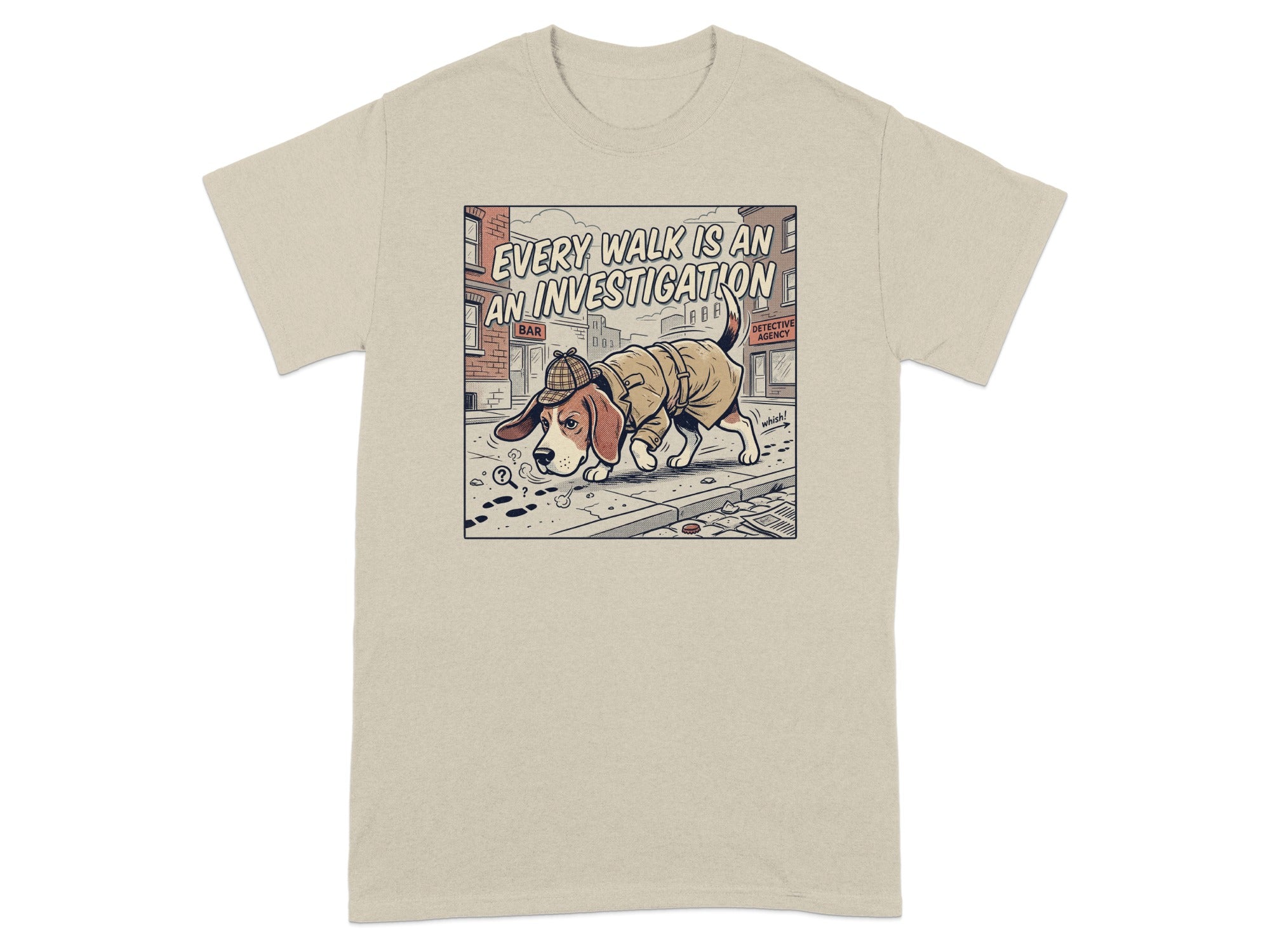 T-shirt graphic of a dog in a trench coat and hat, looking at paw prints.
