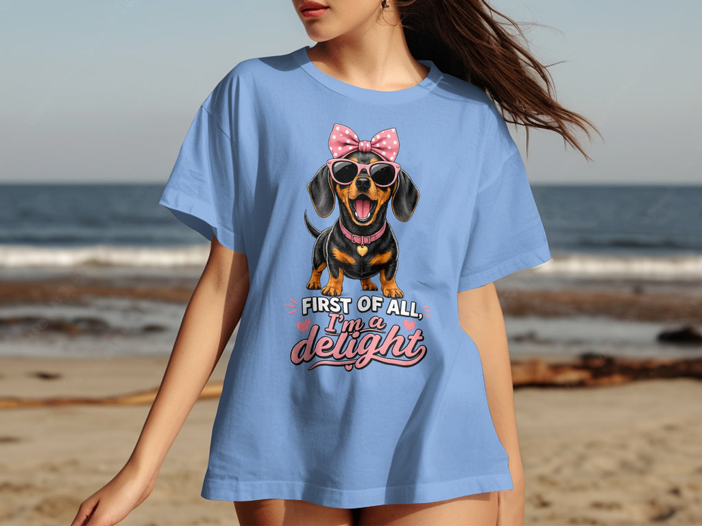 Light blue t-shirt with pink text and sunglasses-wearing dachshund graphic.