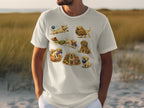 White t-shirt featuring multiple illustrations of golden retriever puppies playing with yarn.