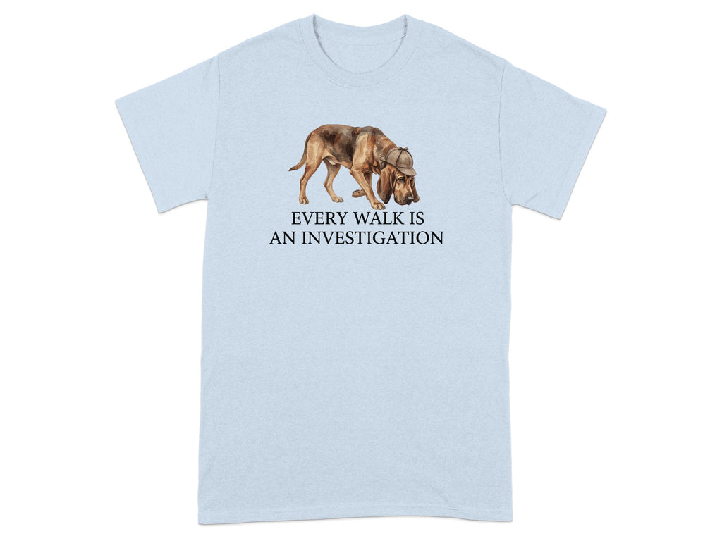 Light blue t-shirt with watercolor dog wearing a hat and the text "EVERY WALK IS AN INVESTIGATION".