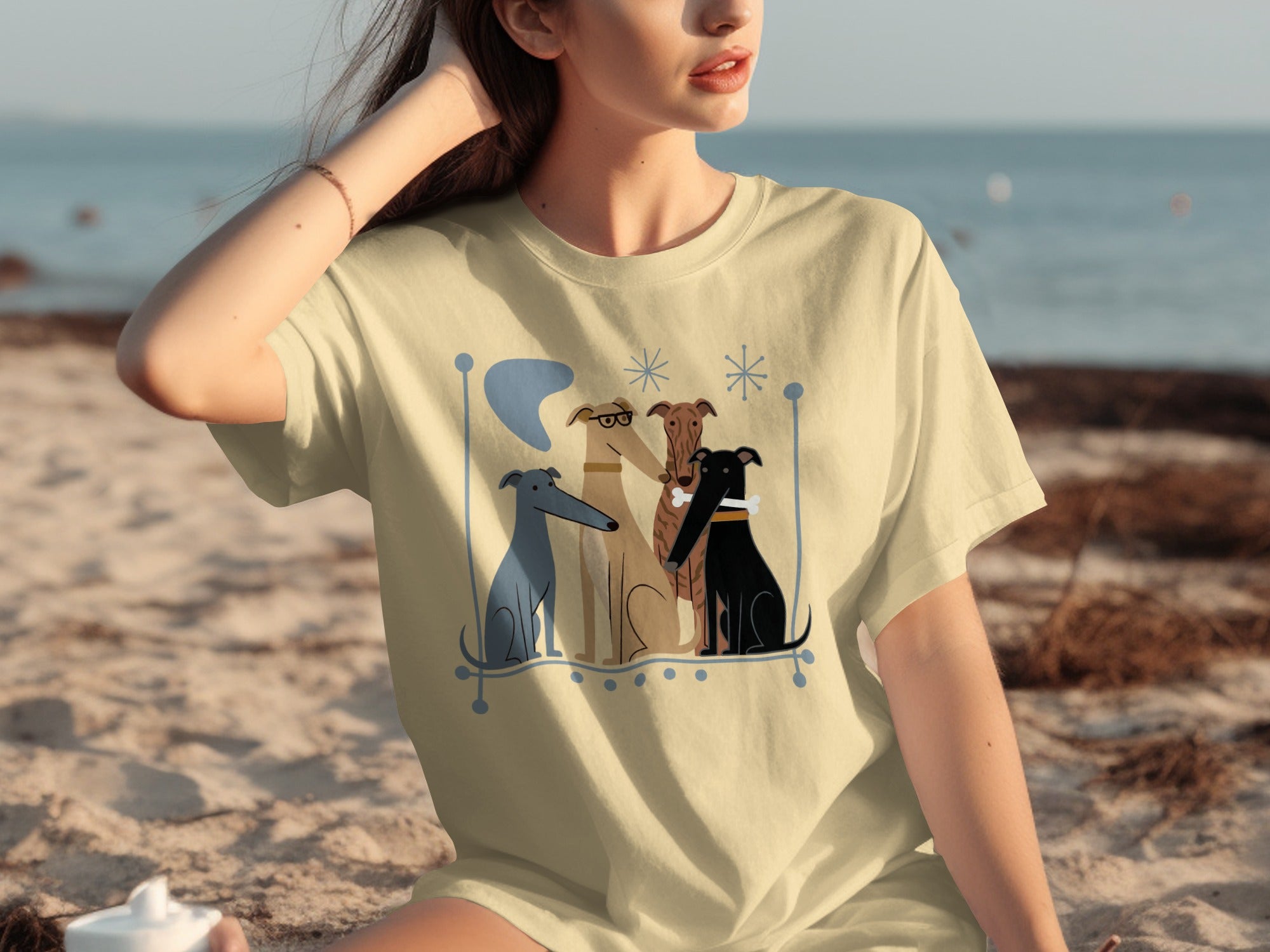 T-shirt with four cartoon dogs in a frame on a beach.