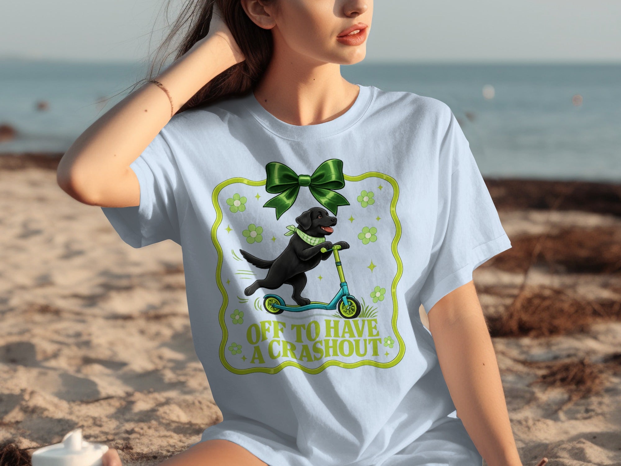 Black lab on scooter with text "Off to have a crashout" on a light blue shirt.