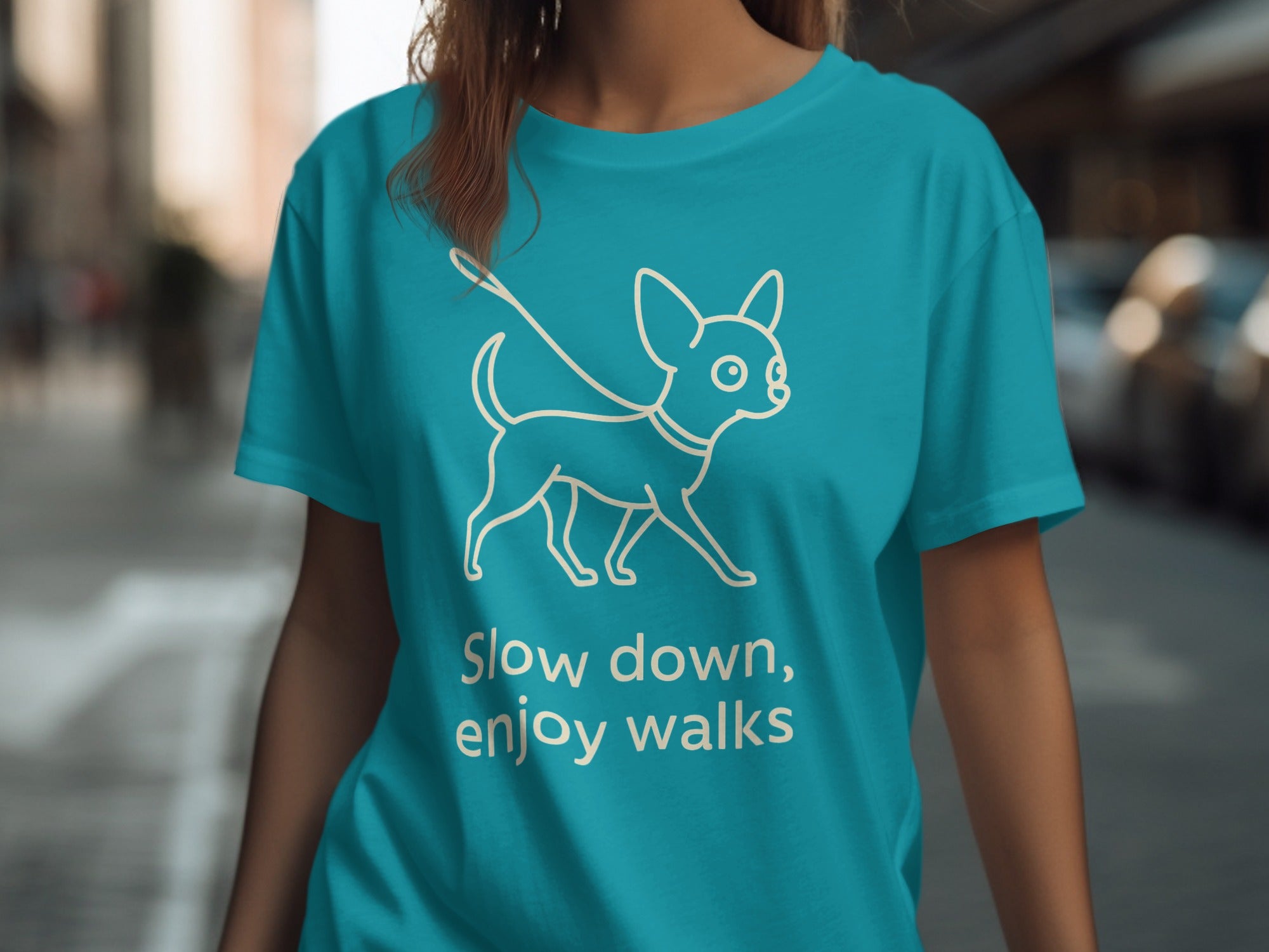 Turquoise t-shirt with white line drawing of a dog on leash and text "Slow down, enjoy walks".