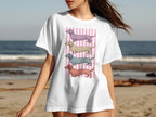 White t-shirt with pink stripes and four colored dachshund illustrations.