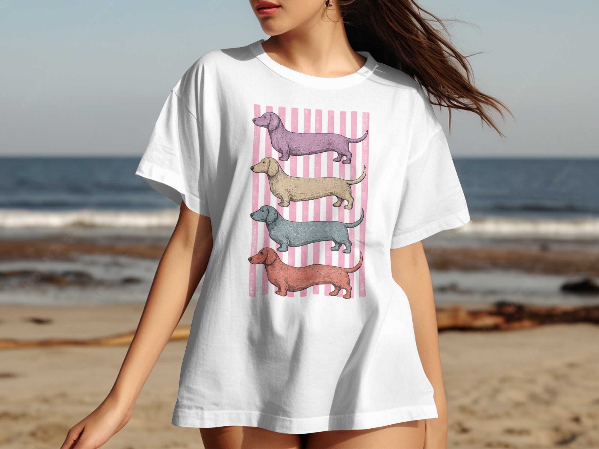 White t-shirt with pink stripes and four colored dachshund illustrations.
