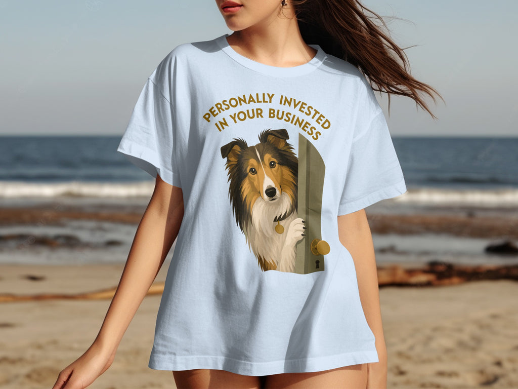 Light blue t-shirt with a dog peeking through a door and text.