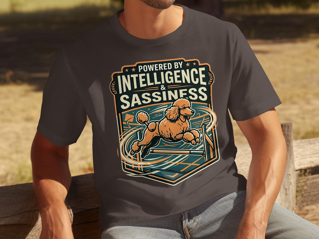 Dark t-shirt with graphic of an apricot poodle jumping over hurdles.