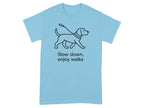 Light blue t-shirt with a black outline of a dog on a leash and text "Slow down, enjoy walks".
