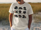 T-shirt with nine cartoon black puppies interacting with books on a white background.