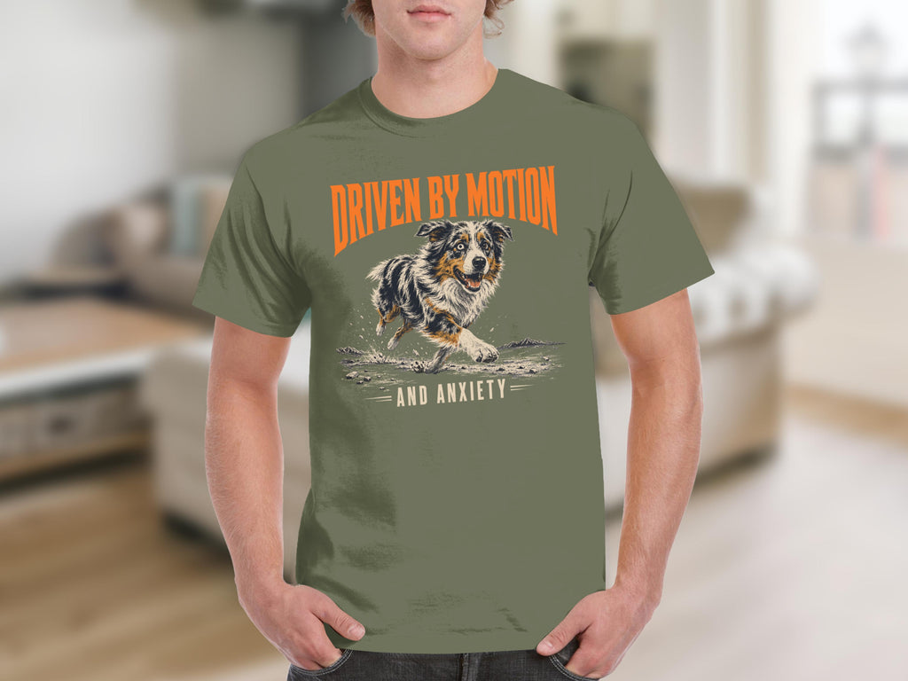 Green t-shirt with a dog running in water, text reads "Driven by Motion and Anxiety".