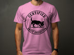 Pink t-shirt with a circular black graphic of a dog wearing a hat and the text "Certified Sniff Inspector".