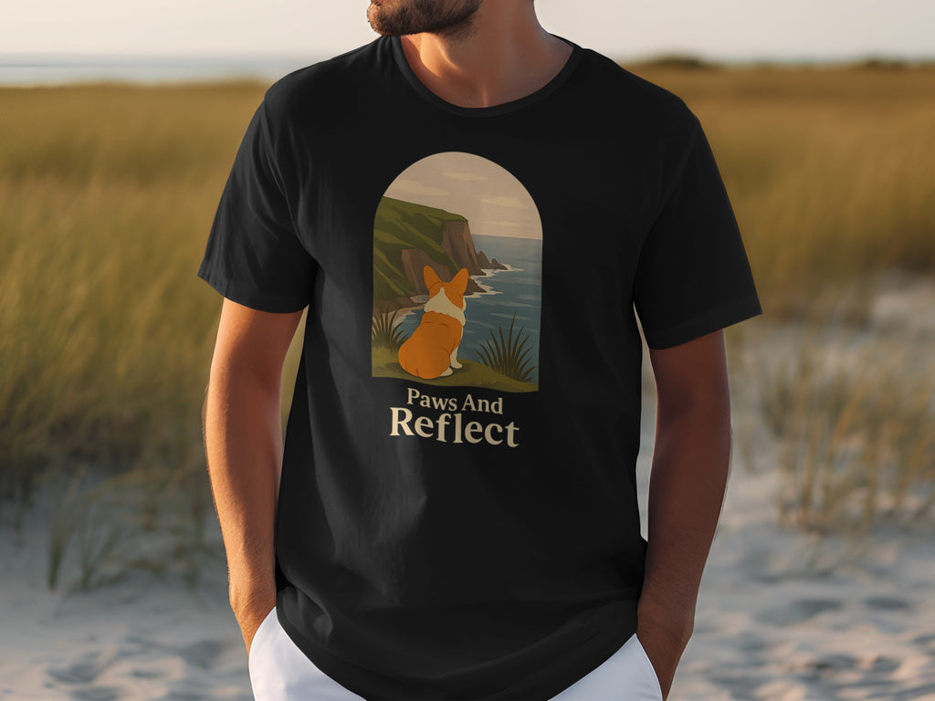 Black t-shirt with a corgi looking out at cliffs and sea, "Paws And Reflect" text.