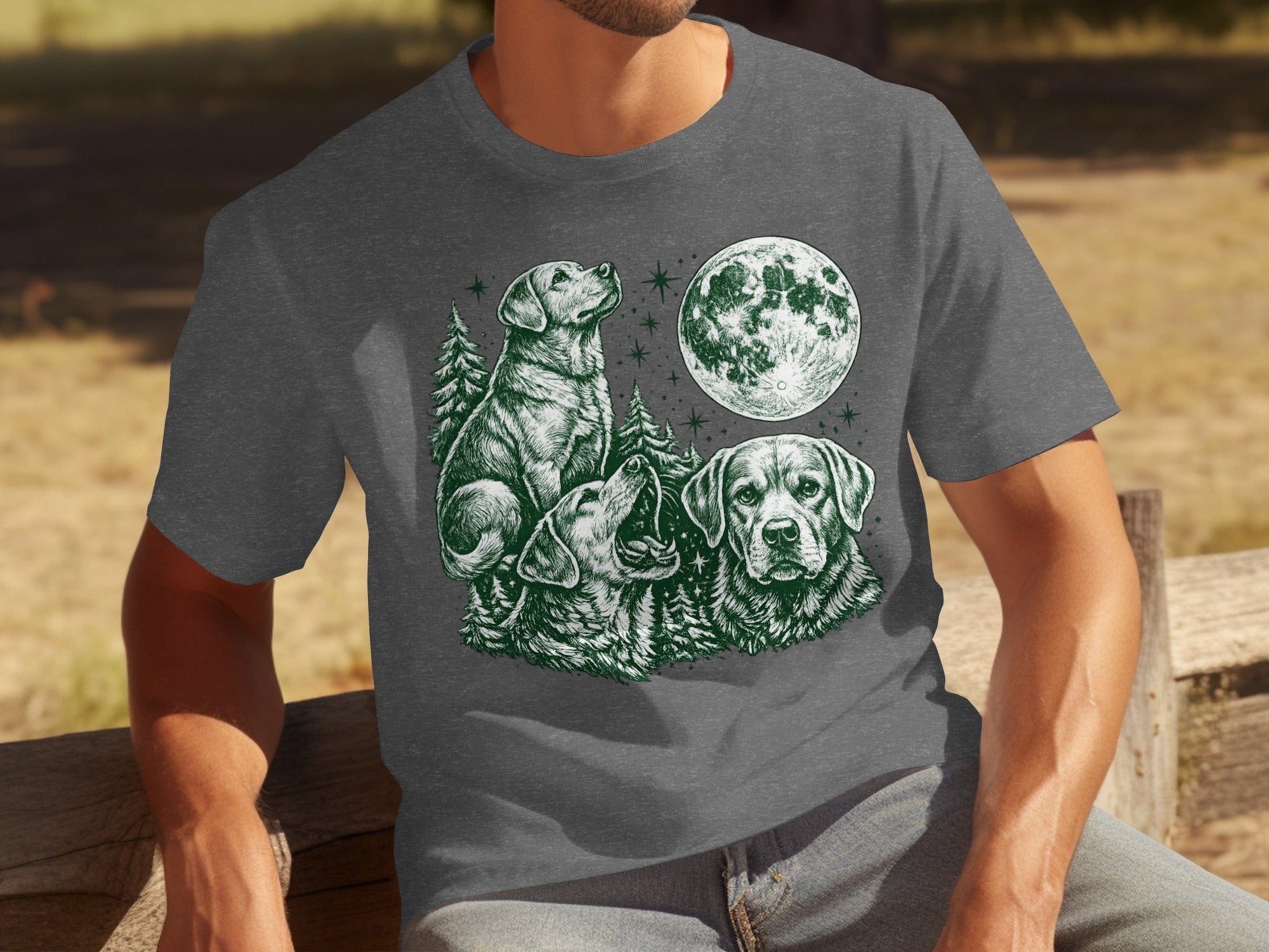 Three dogs and a moon in a dark green sketch on a gray t-shirt.