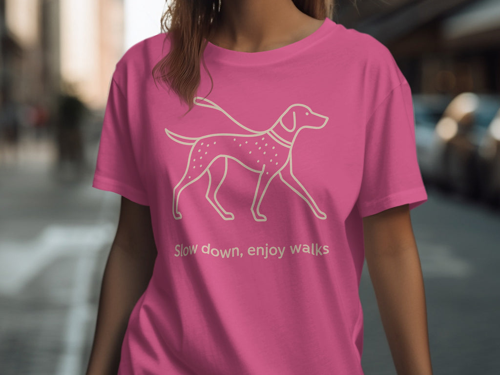 Pink t-shirt with outline of dog and text "Slow down, enjoy walks".