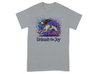 Grey t-shirt with a dog running through colorful paint splatters and text "Unleash the Joy."