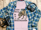 Pink sweatshirt with dog investigation graphic and plaid shirt.