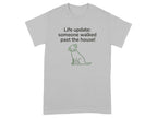 Grey t-shirt with text "Life update: someone walked past the house!" and a dog illustration.